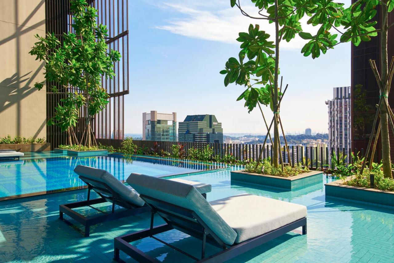 The stunning rooftop pool with sun loungers at Oasia Downtown hotel in Singapore